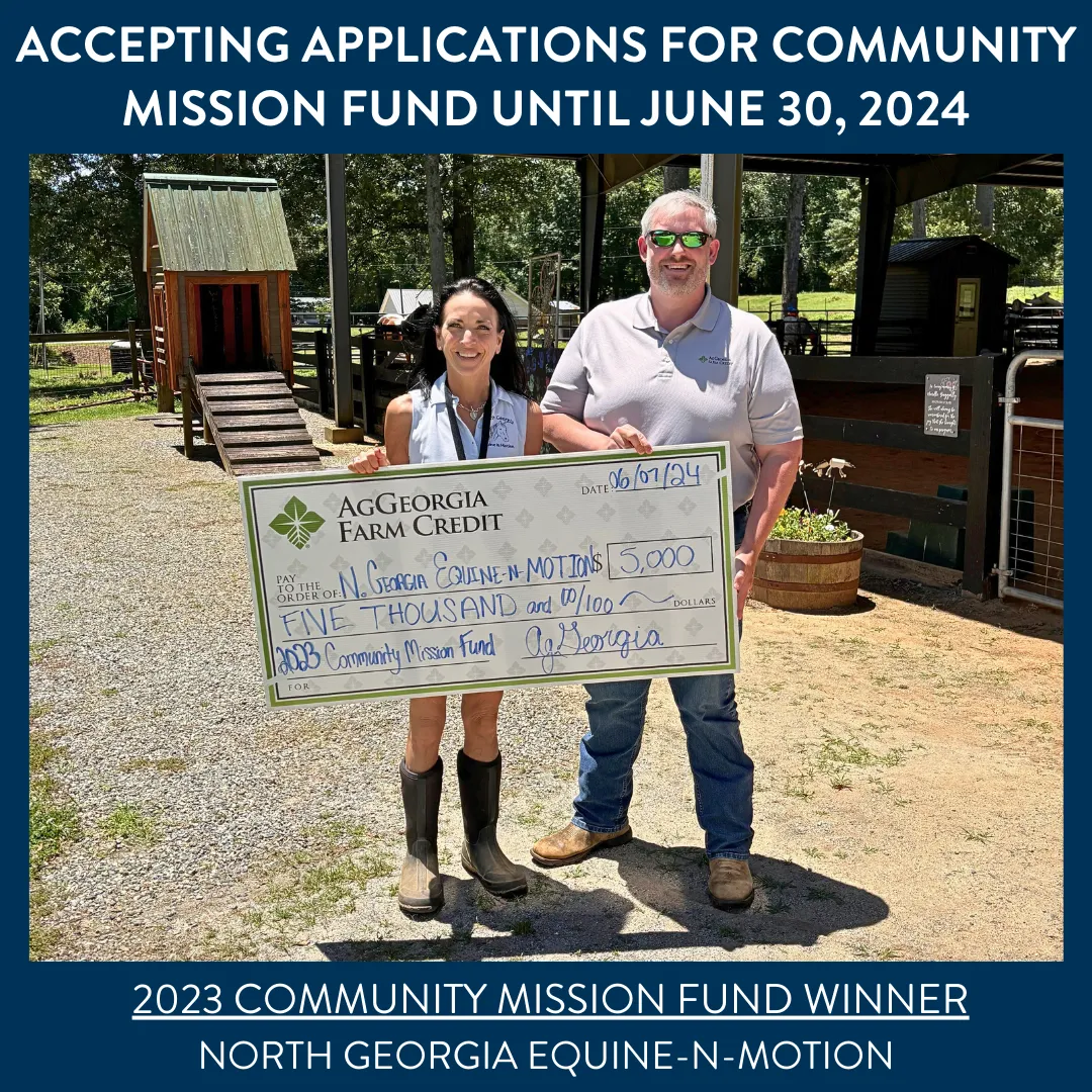 Two people smiling and holding a big check.
