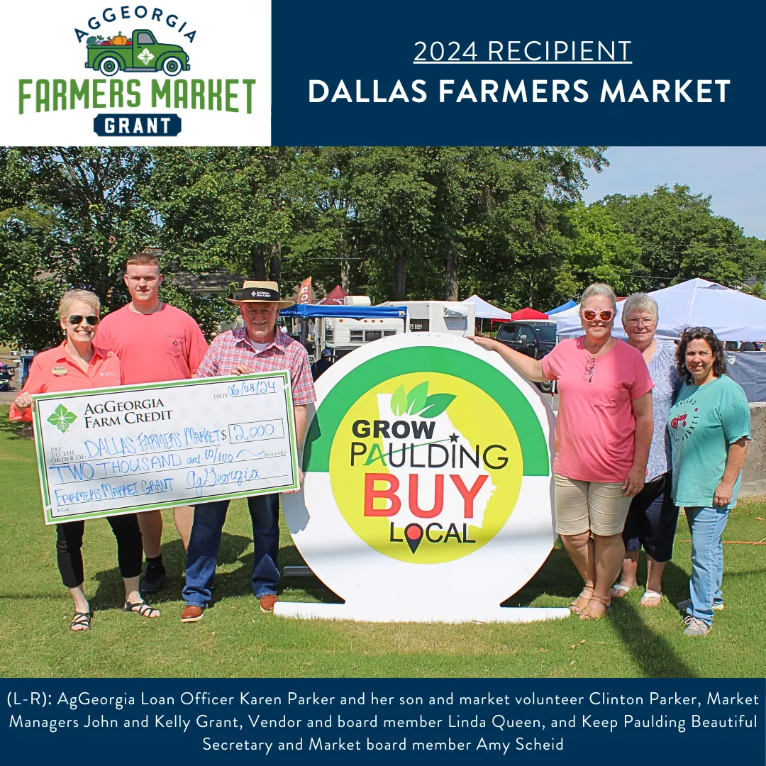 Group of people smiling and holding a big check.