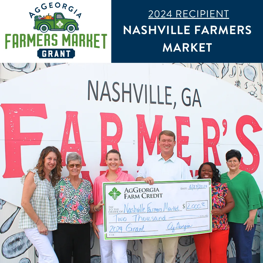 Group of people smiling and holding a big check.