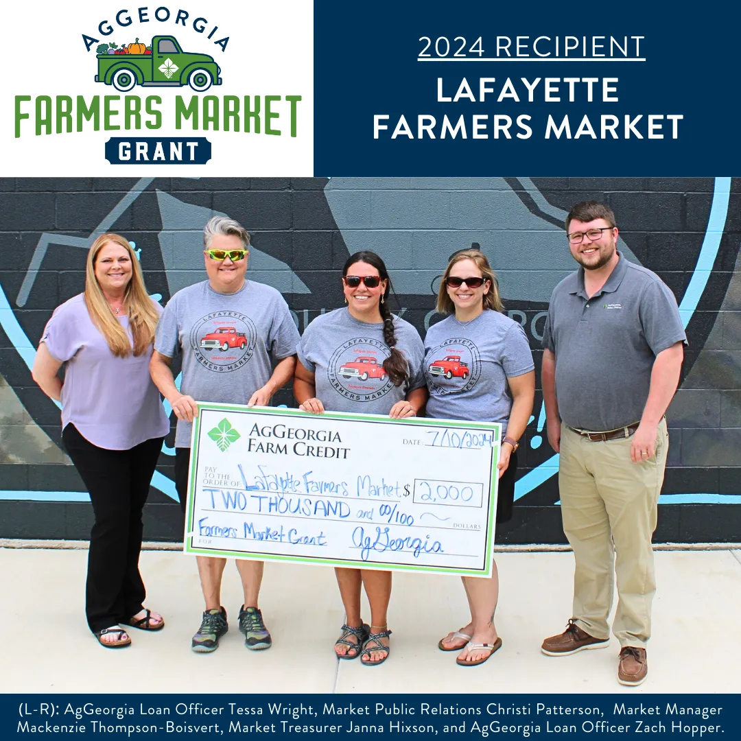 Group of people smiling and holding a big check.