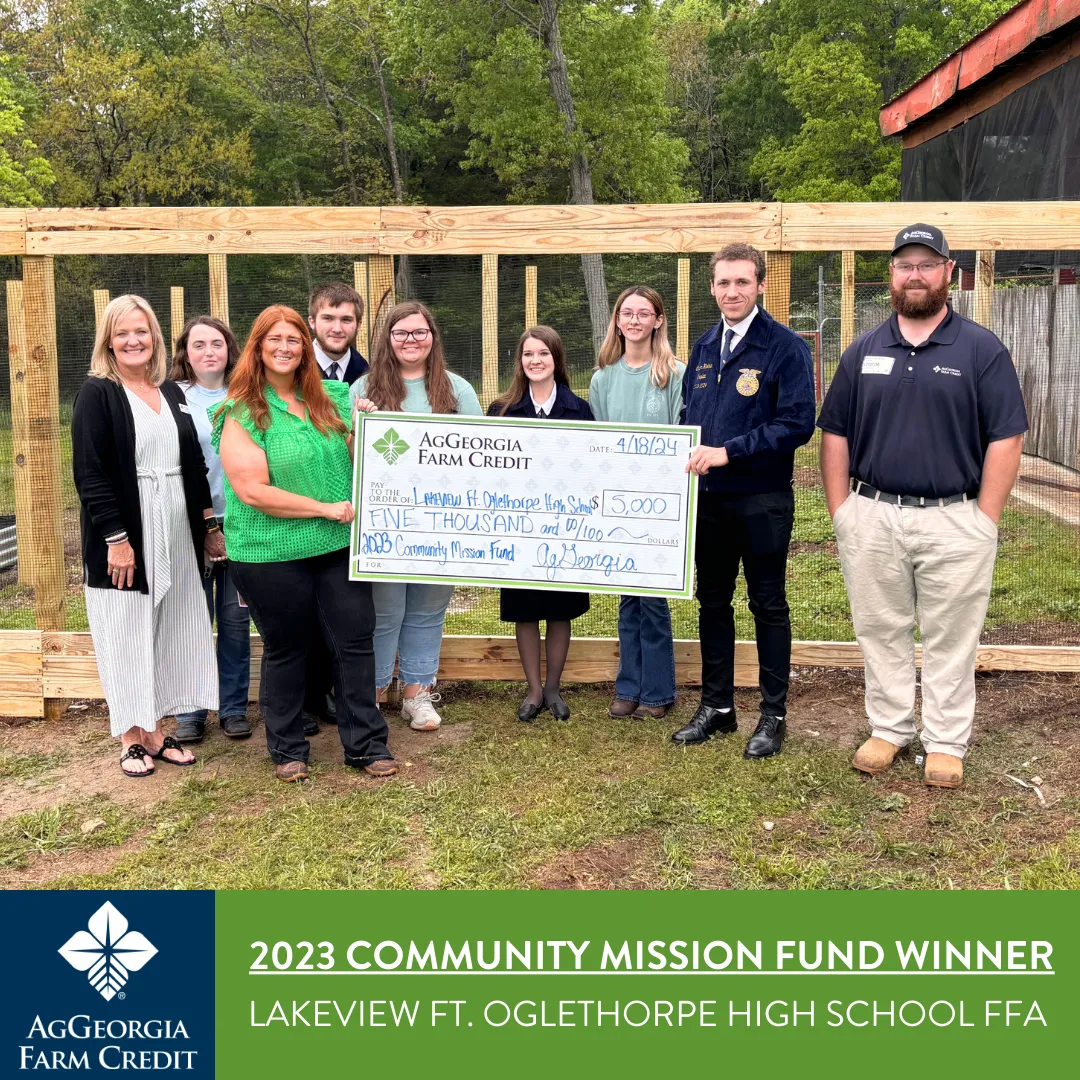Group of people smiling and holding a big check.
