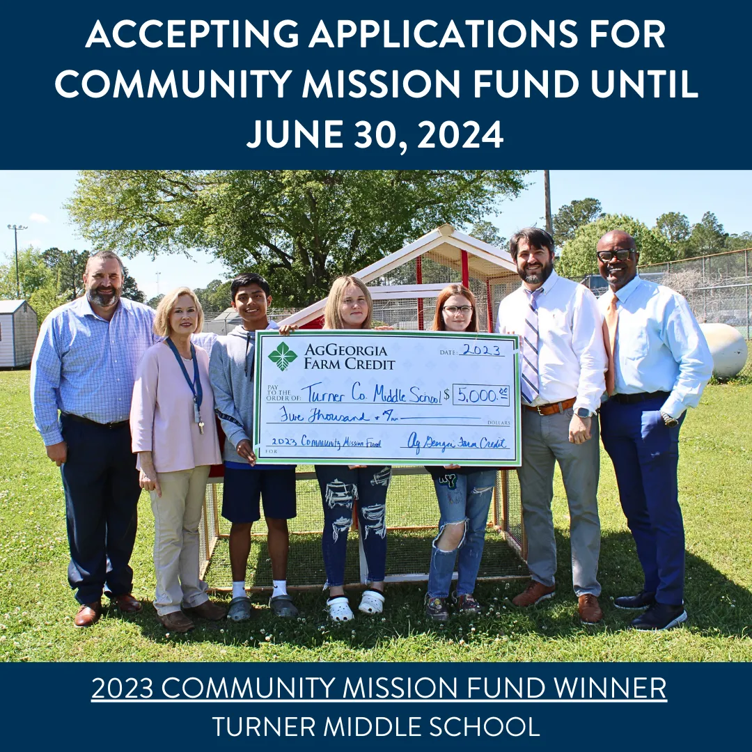 Group of people smiling and holding a big check.